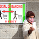 A customer takes a selfie in front of a sign recommending social distancing while waiting to enter the Industry City Costco store on April 28, 2020 in the Brooklyn borough of New York City.